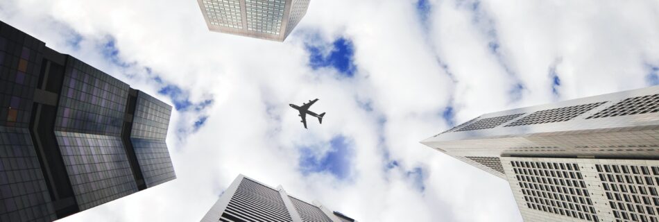 An airplane viewed through skyscrapers.